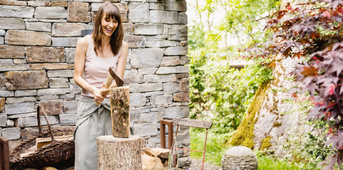 Liste de choses à faire avant d'allumer votre première attisée de la saison - Une femme coupe du bois