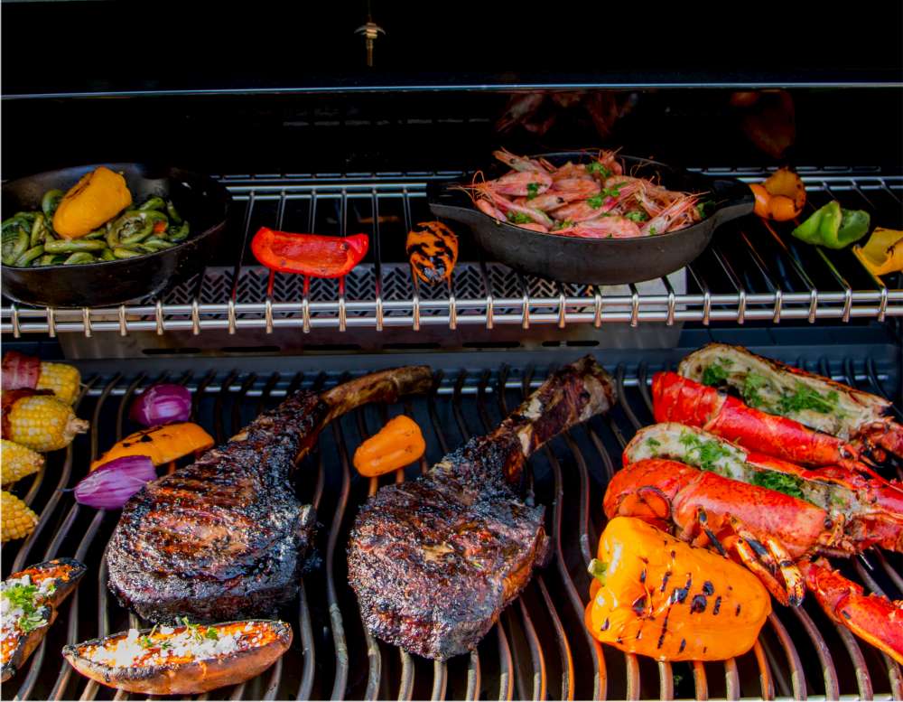 Steak Tomahawk cuit à la perfection sur le BBQ avec des légumes et homards. Comment cuire le parfait steak Tomahawk?