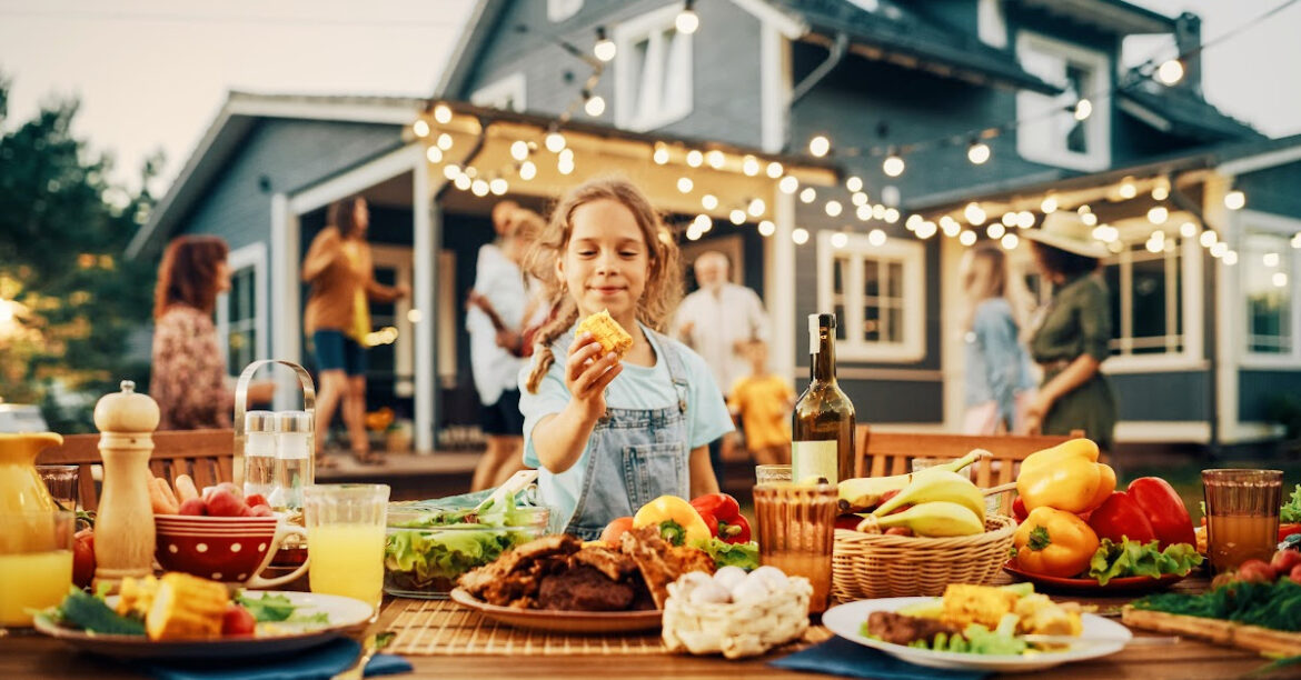 Le délicieux BBQ est-il dangereux? - une jeune fille mange un mais à un barbecue